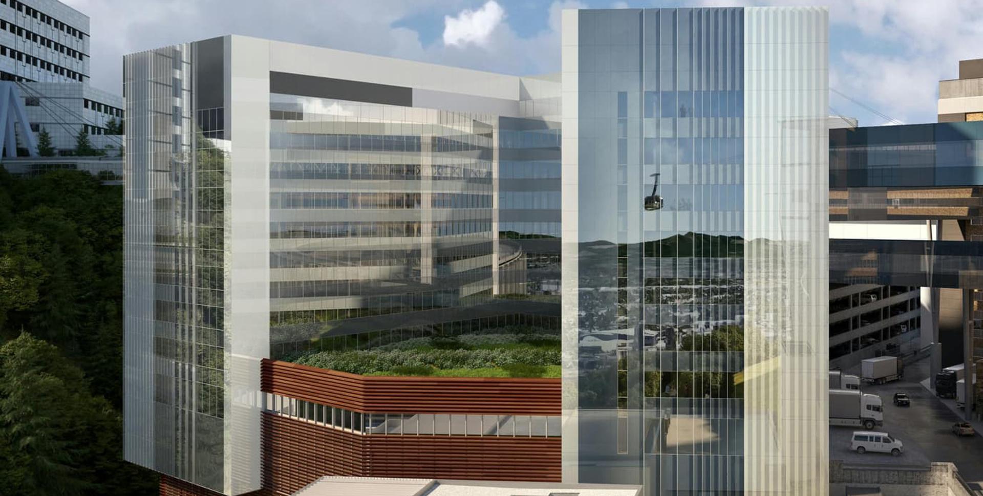 Photo of OHSU Vista Pavilion with a green roof and the aerial tram reflected in the glass façade.
